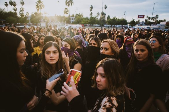 Una multitud de jóvenes, en su mayoría mujeres, se reunieron en una plaza pública durante un evento, y algunos tomaron fotografías con teléfonos inteligentes.