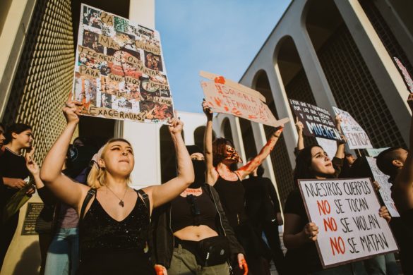 Manifestantes con carteles que abogaban por los derechos de las mujeres durante una manifestación al atardecer.