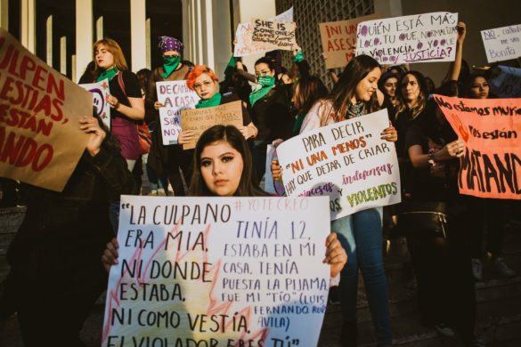 Mujeres sosteniendo carteles de protesta en una manifestación por los derechos y la justicia de las mujeres.